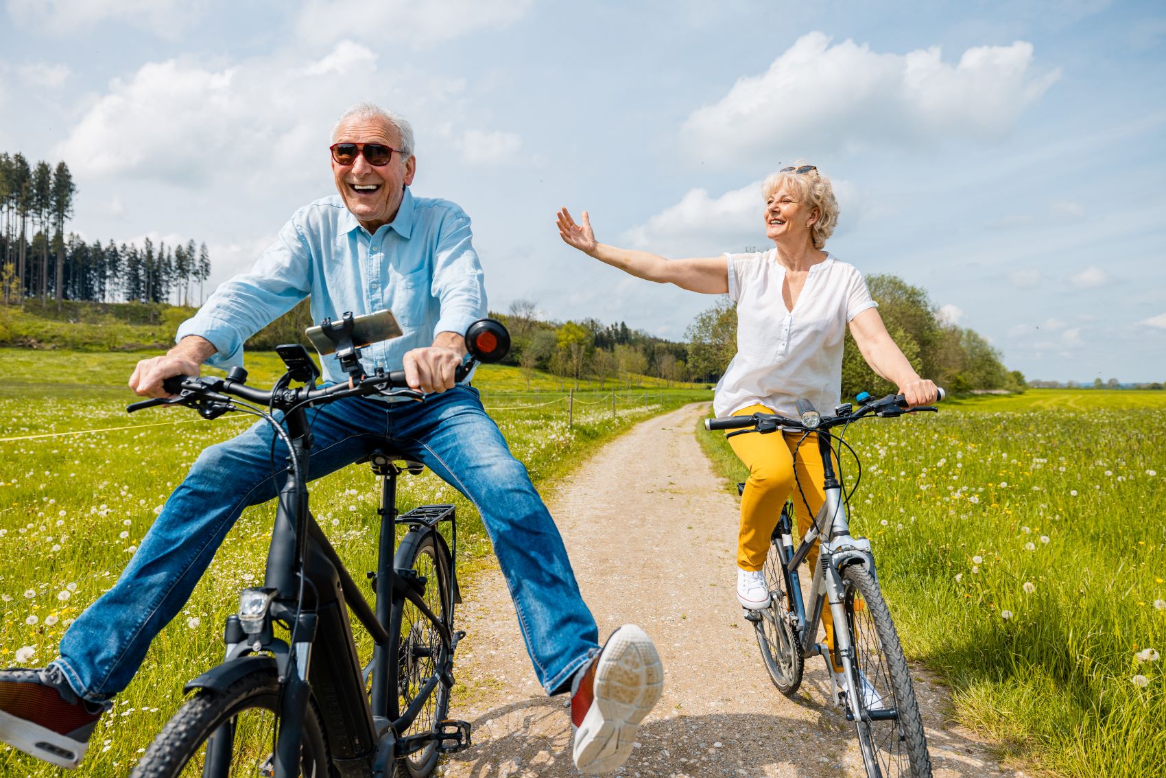 Jubilant man and woman on bicycles on rural gravel